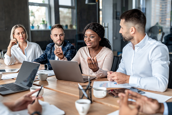 Employees listening to a talking female employee