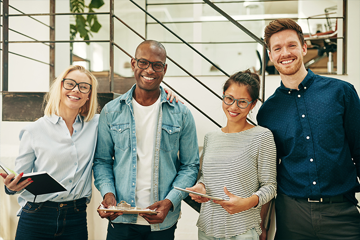 Employees smiling while holding clipboards