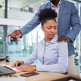 A male employee placing an unwanted hand on the shoulder of a distressed female employee