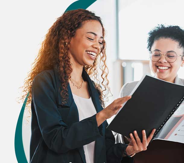 two female co-workers reading handbook