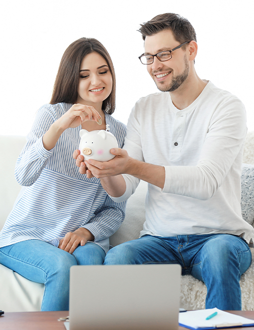 Couple saving money using a piggy bank